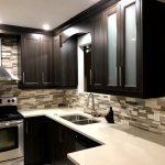 Kitchen: Dark Wood cabinets and composite counters